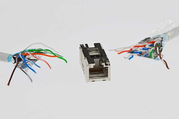 Two cat6 SMTP wires with spread ends close to female LAN Cat6 connector in steel chassis